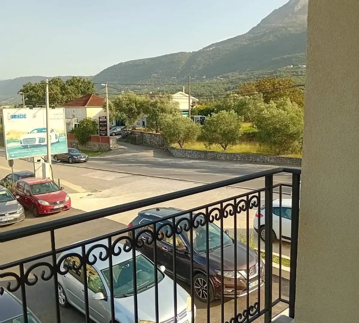 View from the balcony of the surrounding area and parked cars.