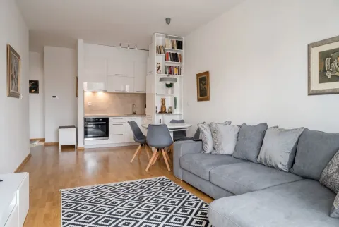 Living room with a sofa and a dining area integrated with the kitchen. - image 4