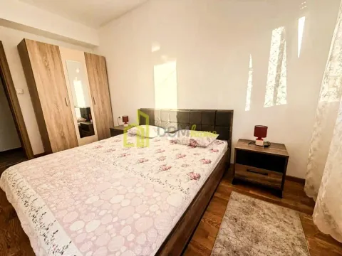 Spavaća soba sa bračnim krevetom, drvenim ormarom i noćnim stočićem. - image 5