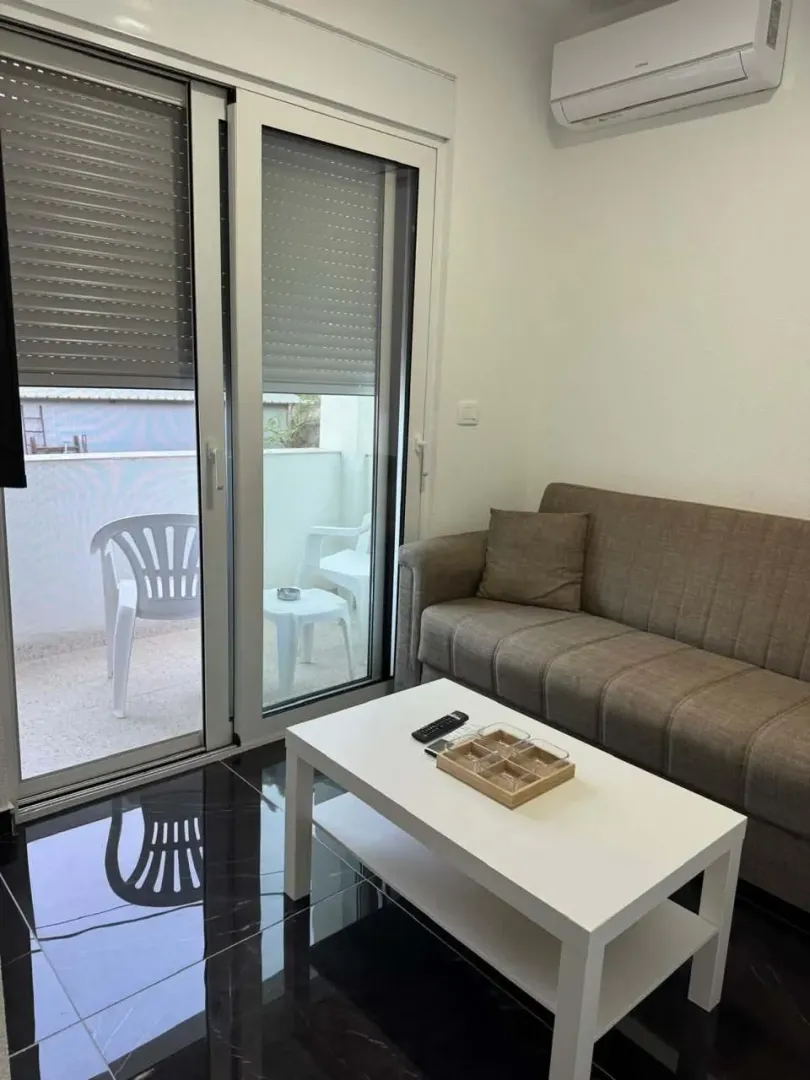 Living room with a sofa, coffee table, and access to the terrace.