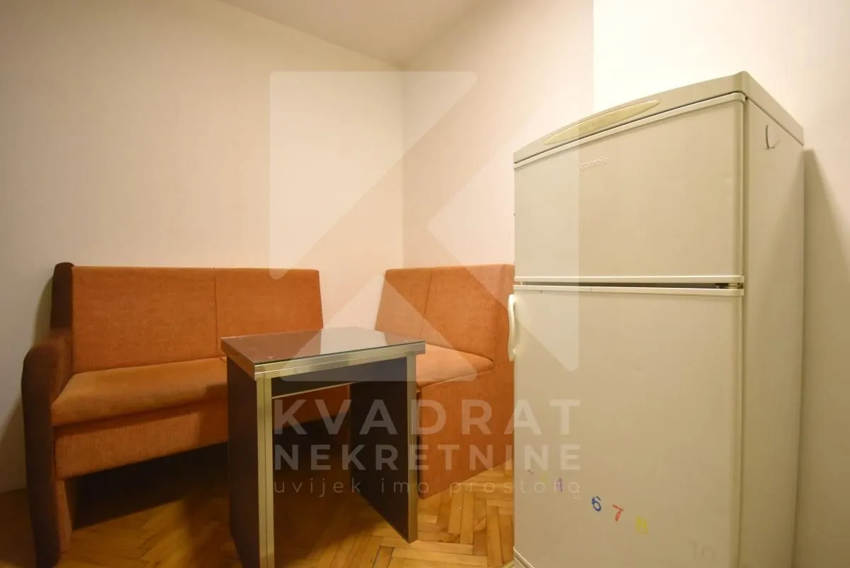 Dnevni boravak sa garniturom za sjedenje, stočićem i frižiderom.