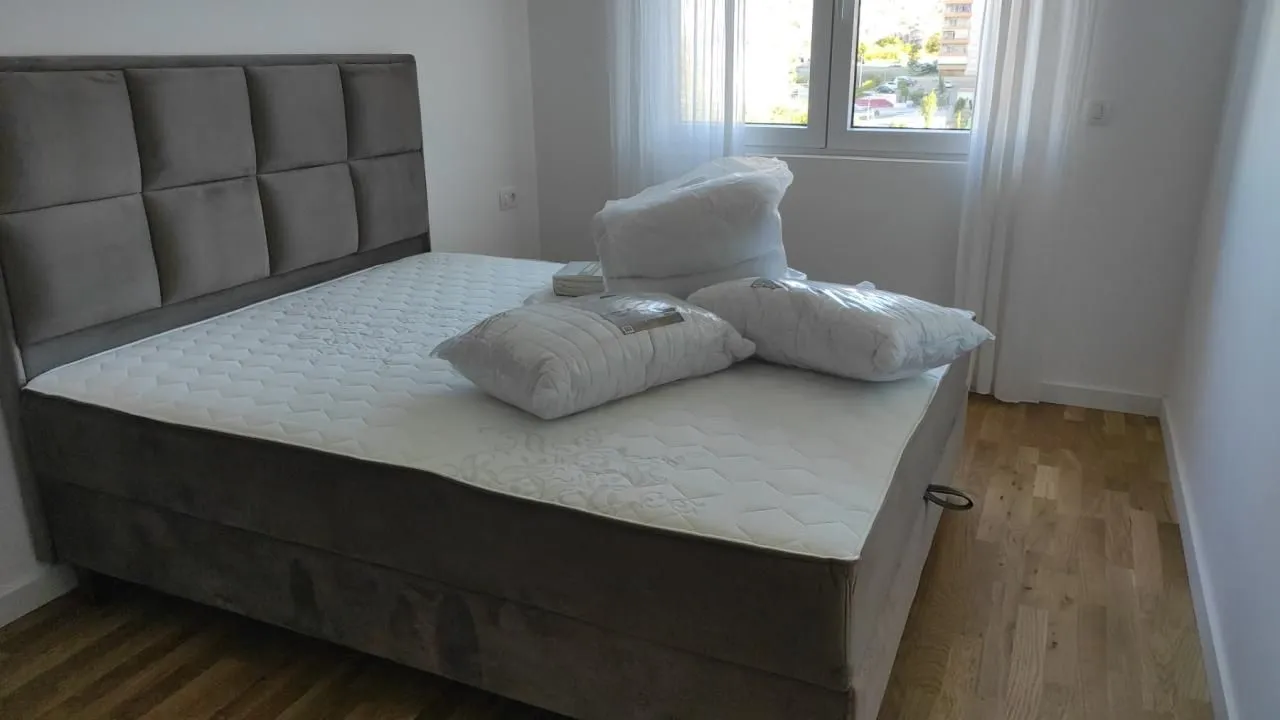 Spavaća soba sa bračnim krevetom i jastucima na dušeku.
