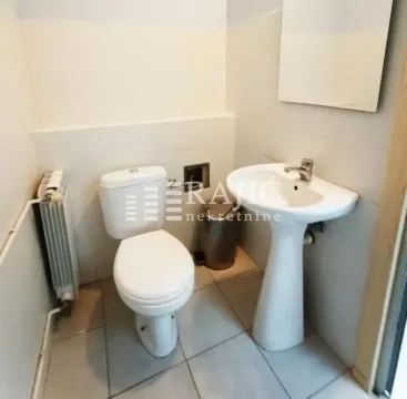 Small bathroom with a toilet, washbasin, and mirror. - image 16