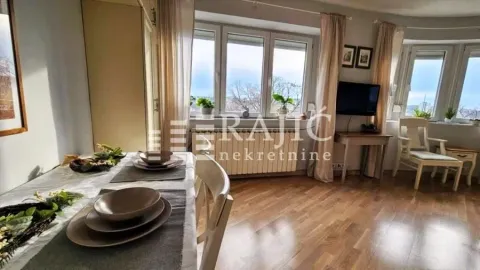 Living room with dining area and large windows. - image 4