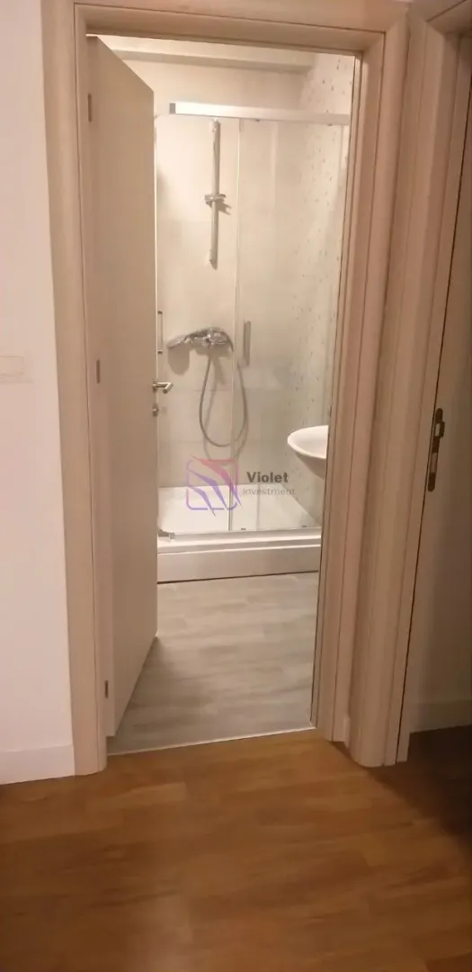 View from the hallway into a modernly decorated bathroom with a walk-in shower.