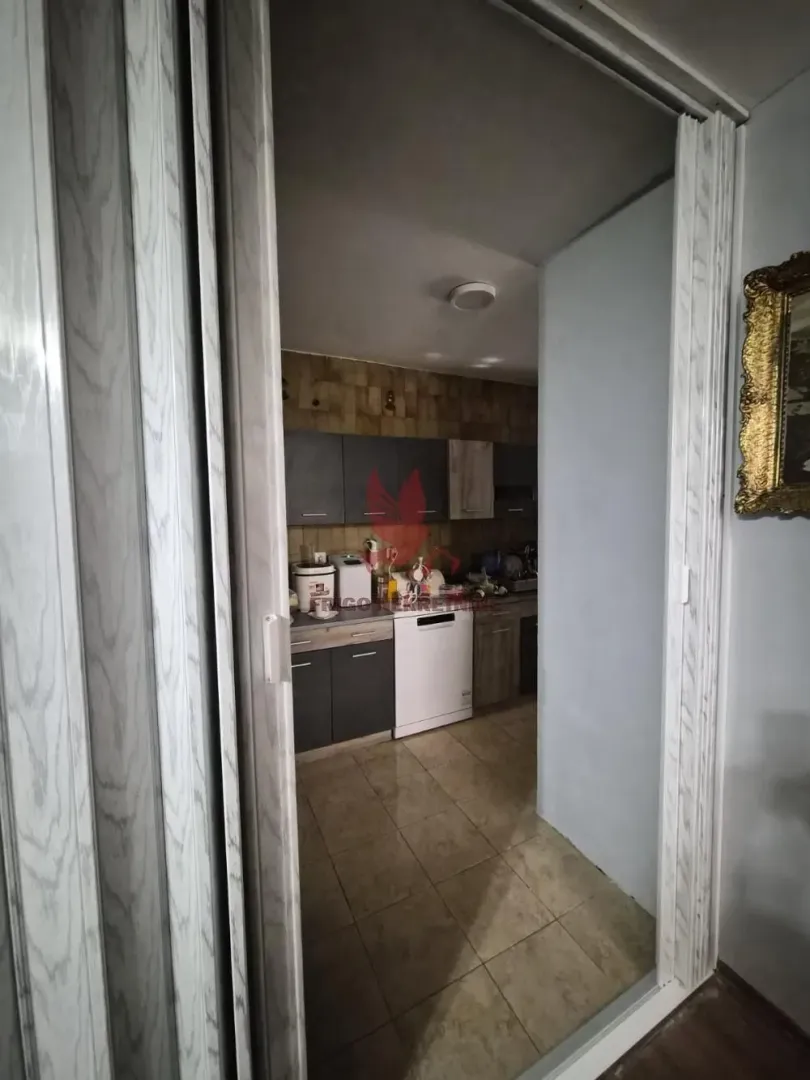 View from the hallway into the kitchen with cabinets and appliances.