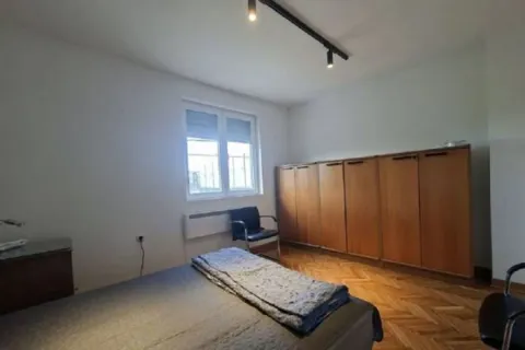 Bedroom with a bed, a large wooden wardrobe, and a window. - image 8