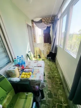 Zastakljena terasa sa stolom, stolicama i neredom. - image 8