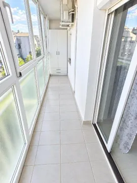 Zastakljeni balkon sa keramičkim pločicama na podu i ugradnim ormarom. - image 17