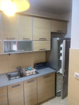 A bright kitchen with wooden cabinets and a refrigerator. - image 8