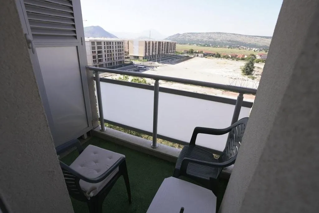 Manji balkon sa garniturom za sjedenje i pogledom na okolinu.