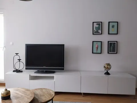 Bright living room with a TV on a white console. - image 5