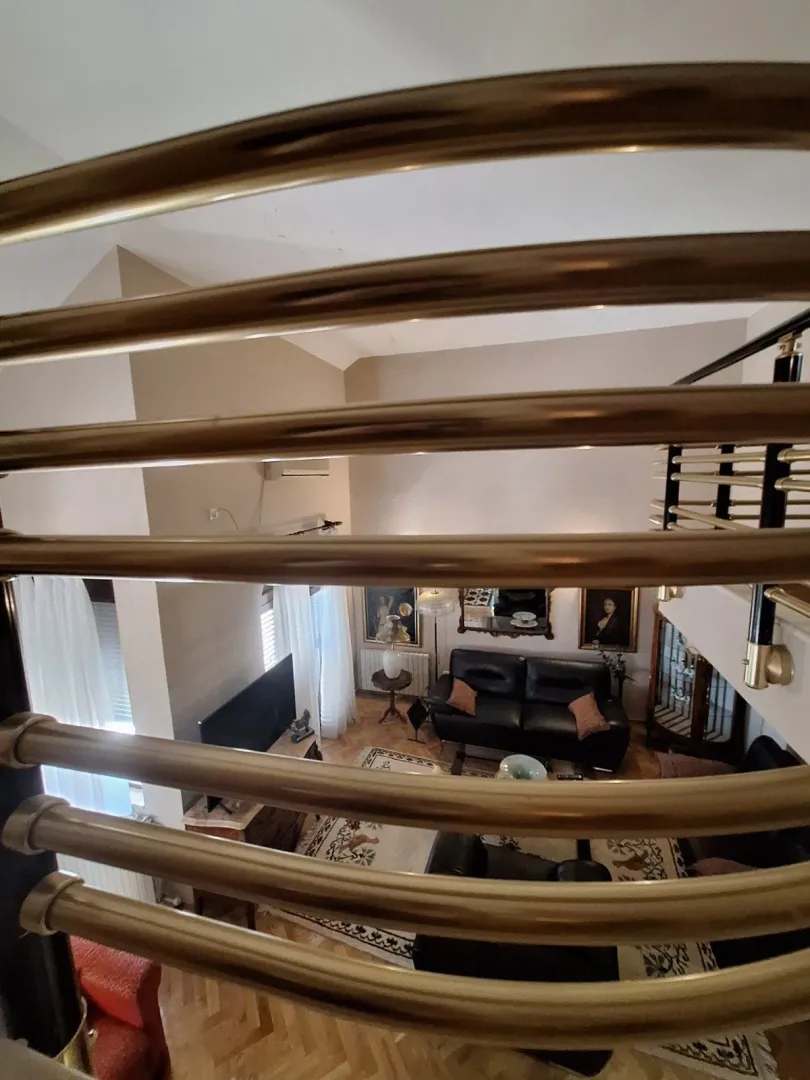 View from the upper floor down into the living room through a decorative staircase railing.