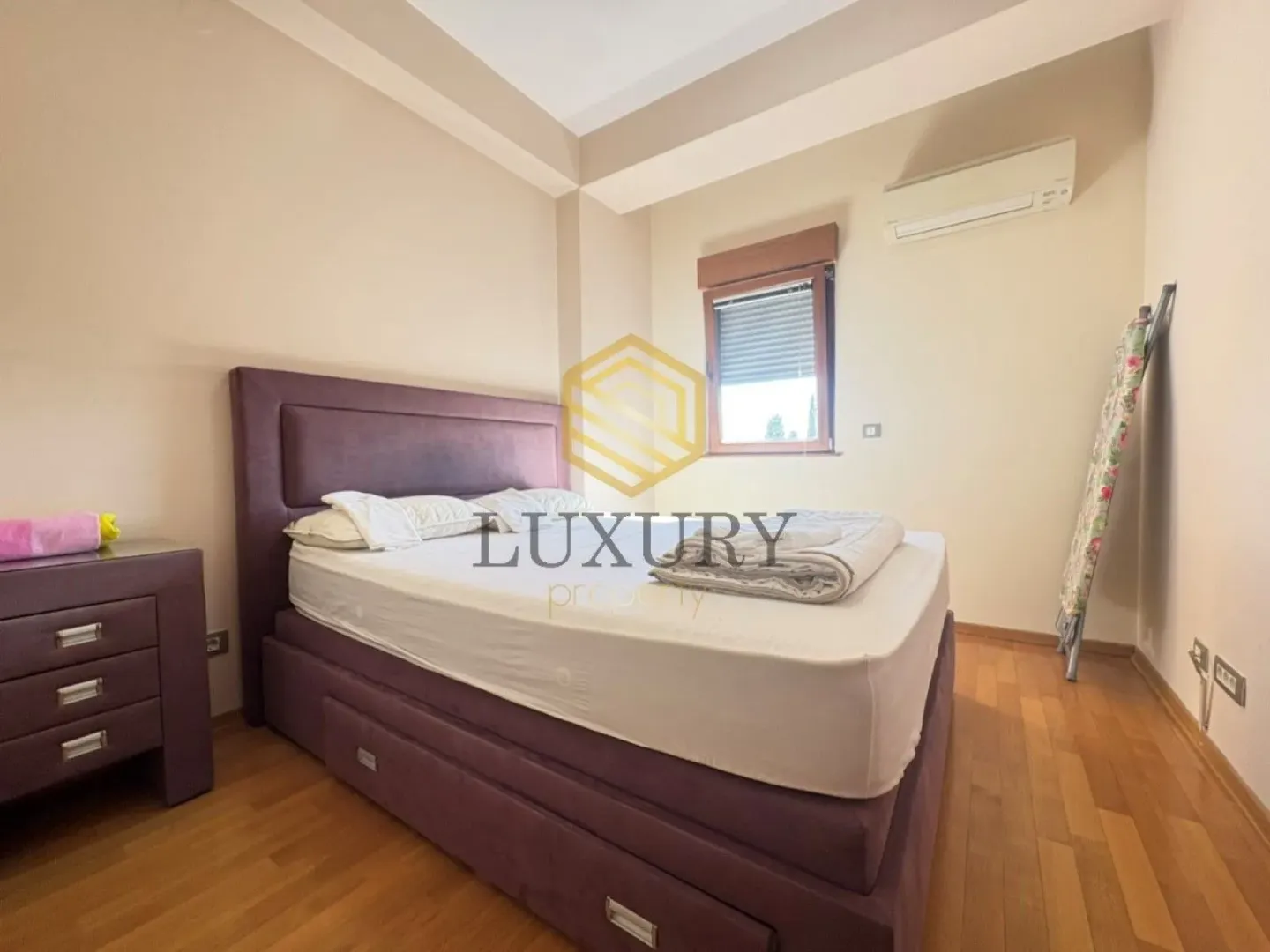 Bedroom with a double bed, dresser, and air conditioning unit.