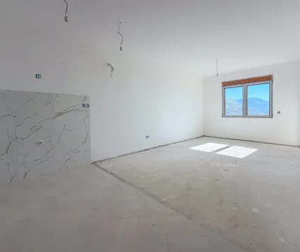 Nezavršena prostorija sa bijelim zidovima, pločicama na dijelu zida i prozorom koji gleda na planine. - image 3