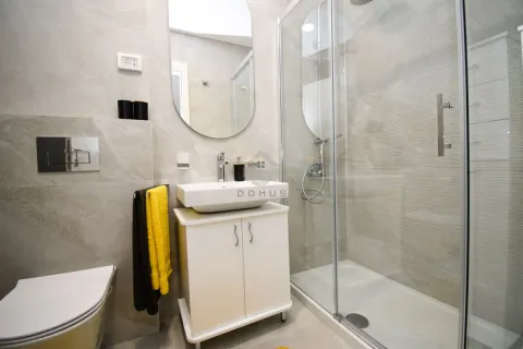A modern bathroom equipped with a shower cabin, washbasin, and a wall-mounted toilet. - image 10