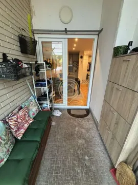 Natkriveni balkon opremljen klupom za sedenje, policama za obuću i ormarićem. - image 16
