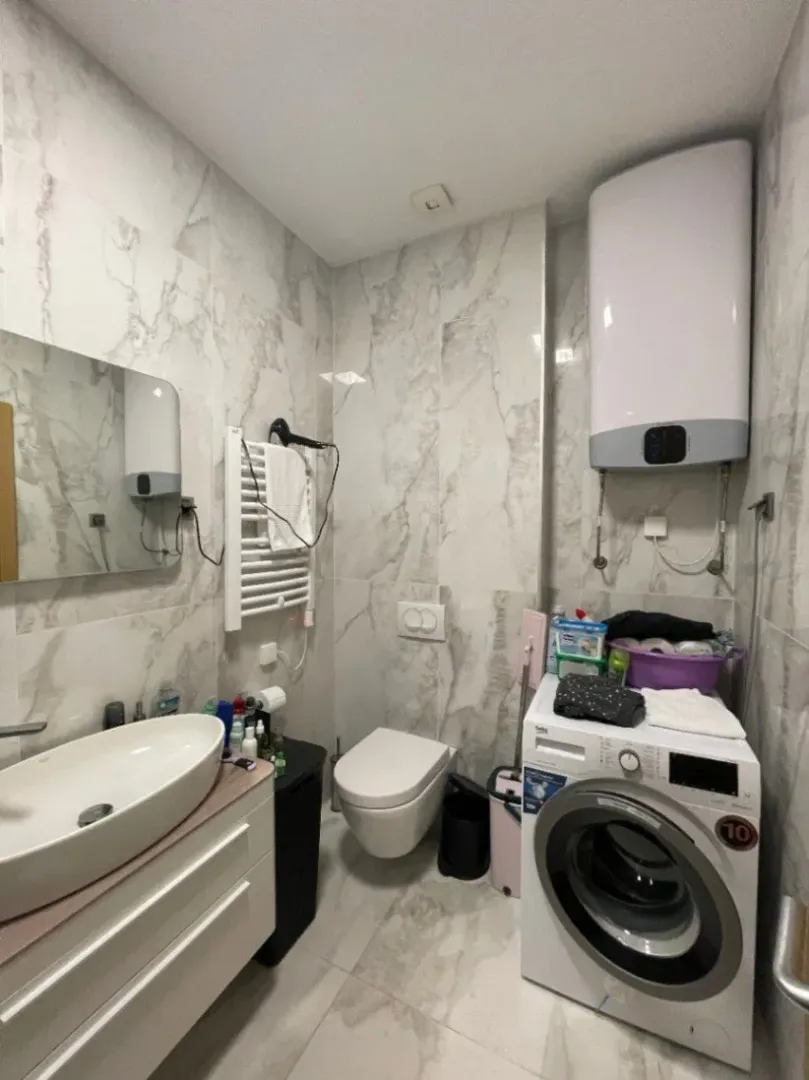 Bright bathroom with a washing machine and modern fixtures.
