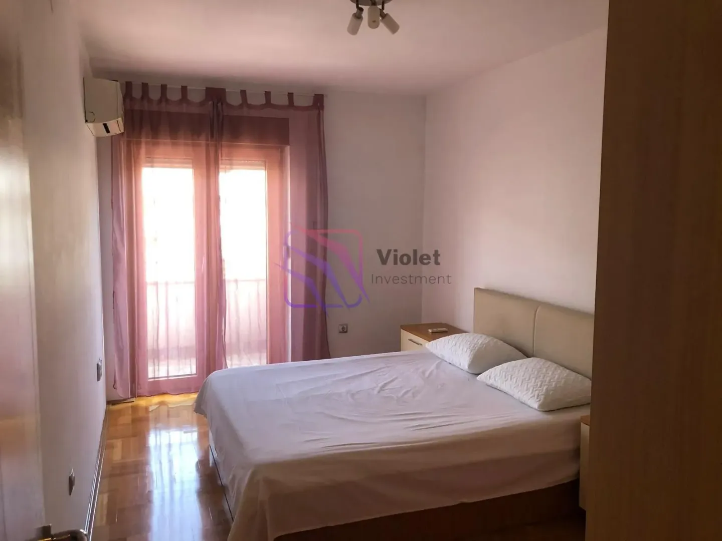 Spavaća soba sa bračnim krevetom i izlazom na terasu.