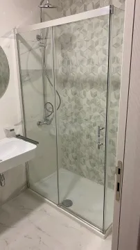 Modern shower cabin and sink in a bright bathroom. - image 8