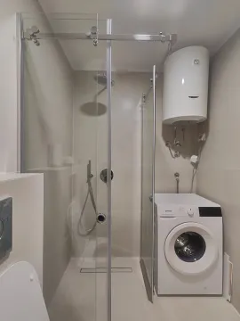Moderno opremljeno kupatilo sa tuš kabinom i veš mašinom. - image 9