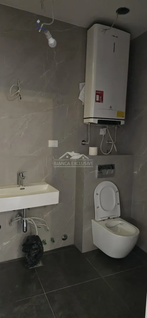 Novoopremljeno kupatilo sa umivaonikom, WC šoljom i bojlerom.