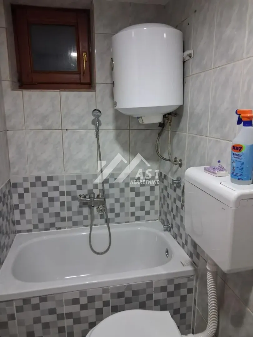 Manje kupatilo sa kadom, bojlerom i WC šoljom.