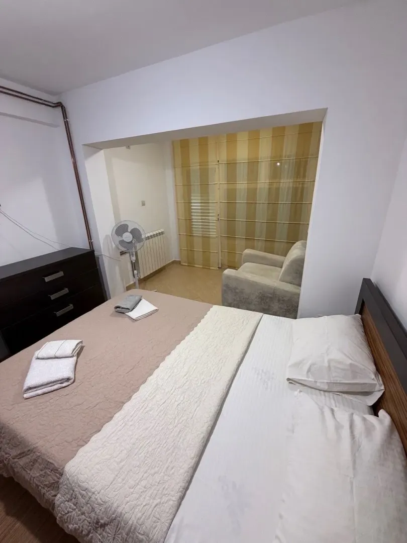 Bedroom with a double bed and an open passage to a smaller sitting area.