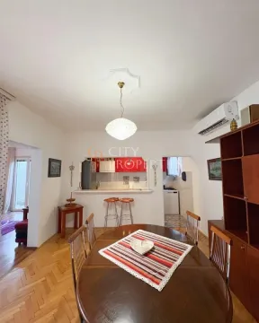 Dining area with a wooden table and chairs, overlooking the breakfast bar and kitchen in the background. - image 11