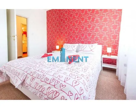 Furnished bedroom with a double bed and red wallpaper. - image 4