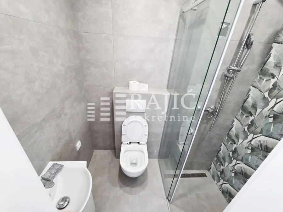 Modernly equipped bathroom with a walk-in shower and sanitary fixtures.