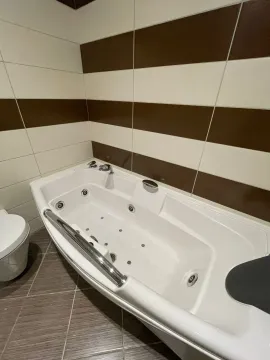 Kupatilo sa hidromasažnom kadom i keramičkim pločicama u braon i bijelim tonovima. - image 10