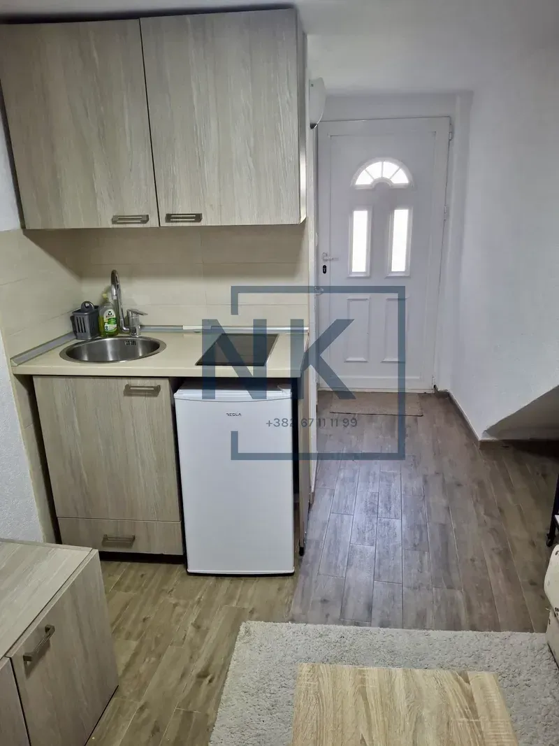 Small kitchen with a sink, built-in cooktop, and refrigerator.