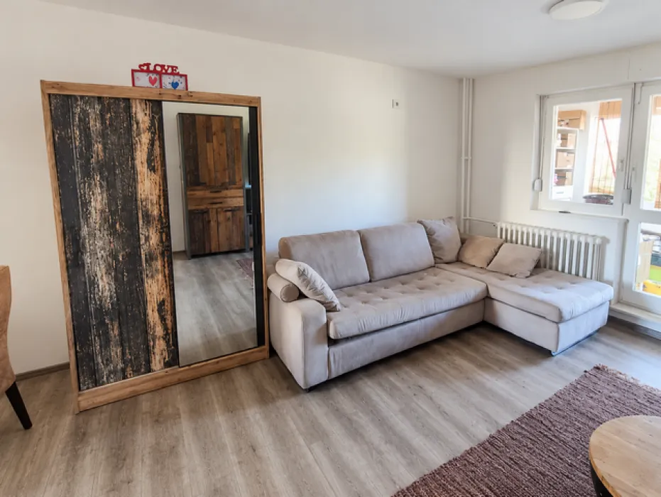 Living room with a sectional sofa, a large wardrobe with a mirror, and access to the terrace.