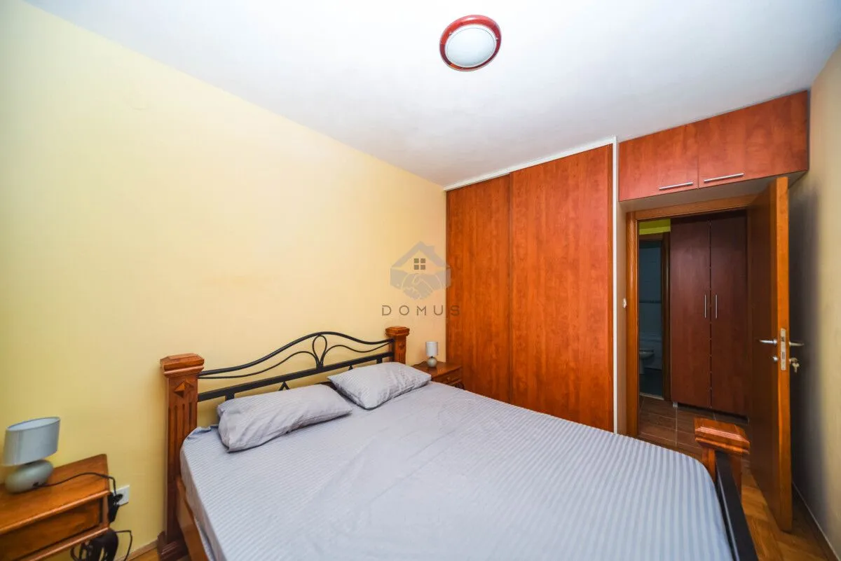Bedroom with a double bed, wooden wardrobe, and nightstands.