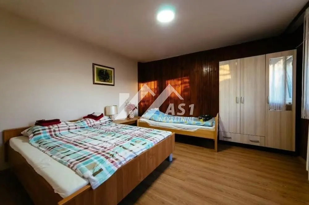 Bedroom with two beds and a wooden wardrobe.