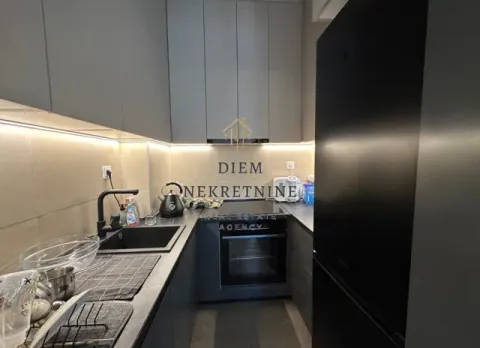 Moderna kuhinja sa tamnim elementima i ugrađenom rernom. - image 4
