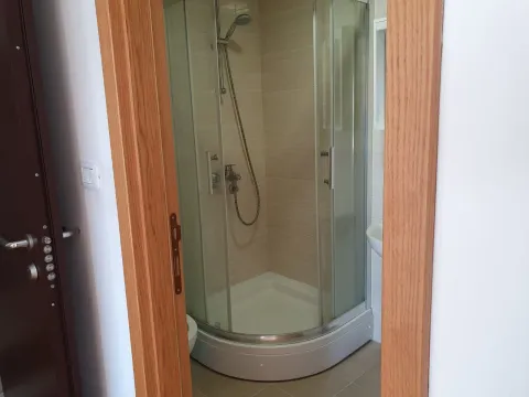 Kupatilo sa staklenom tuš kabinom viđeno kroz otvorena vrata. - image 10