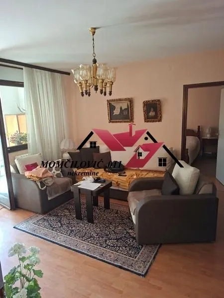 Dnevna soba sa garniturom, stočićem i tepihom.