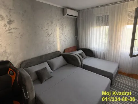 Dnevna soba sa sivom garniturom i klima uređajem. - image 8