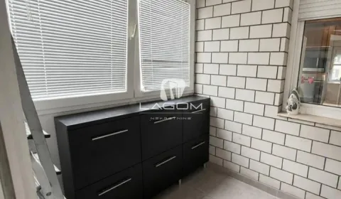 Enclosed balcony with a black cabinet and tiled walls. - image 19
