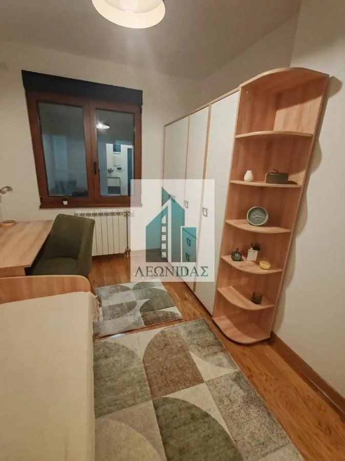 Small bedroom with a bed, desk, and large wardrobe.
