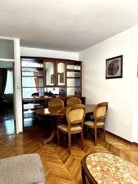 Trpezarijski sto sa stolicama i drvena vitrina u prostranom dnevnom boravku. - image 3
