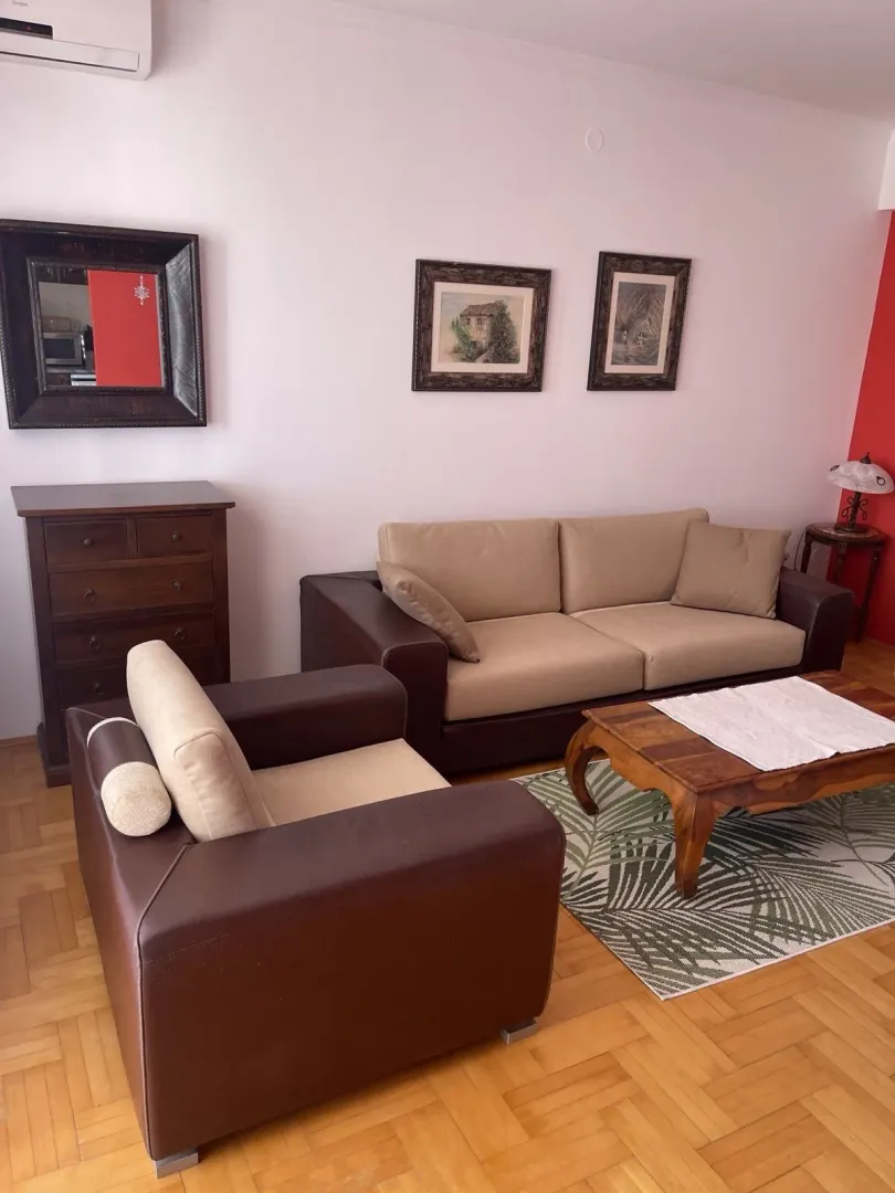 Bright living room with leather furniture and wooden cabinets.