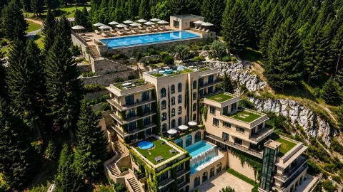 Pogled iz vazduha na luksuzni hotelski kompleks sa bazenima okružen šumom. - image 7