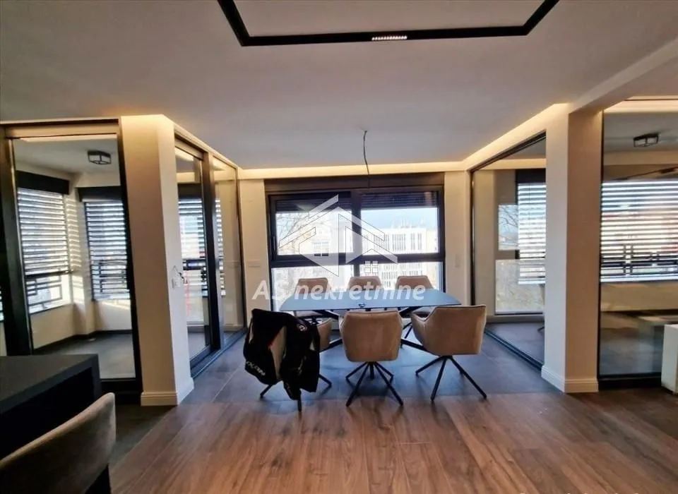 Living room with a dining area and large glass surfaces.