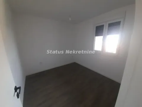 Prazna soba sa belim zidovima i tamnim laminatom. - image 8
