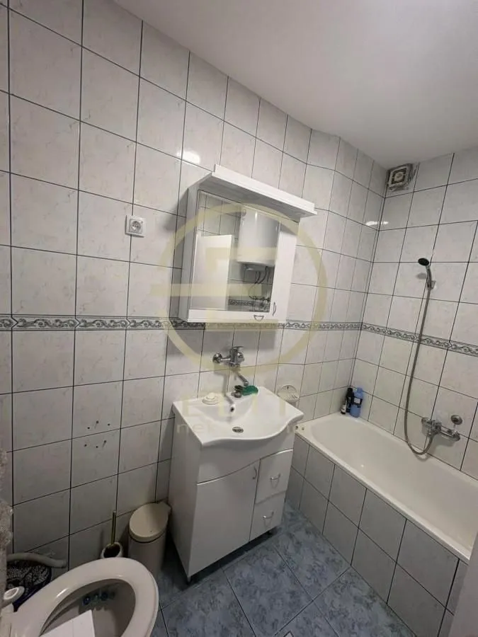 Kupatilo opremljeno umivaonikom, ormarićem, kadom i wc šoljom.