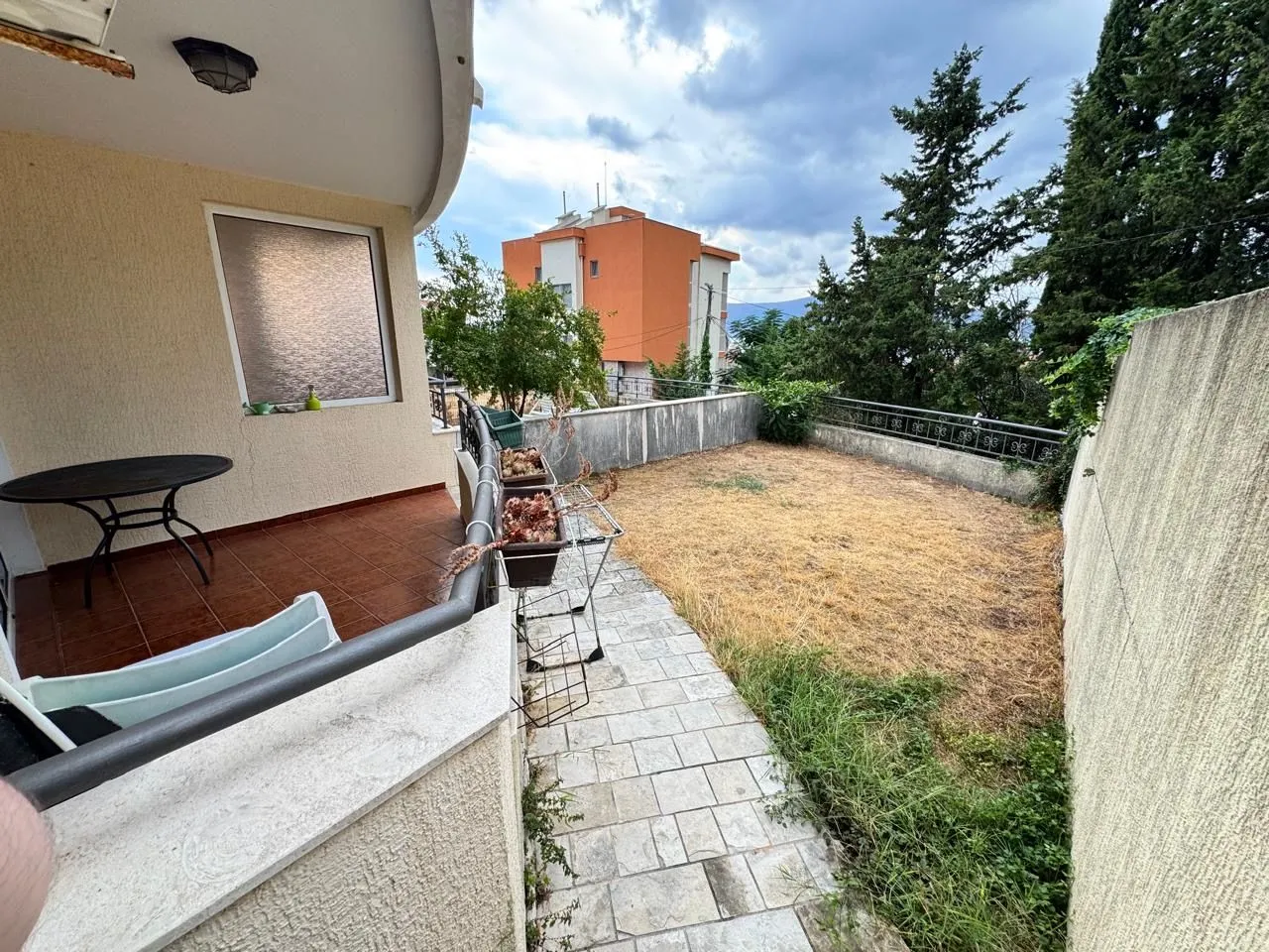 Terasa sa stolom i pogledom na dvorište i okolne zgrade.