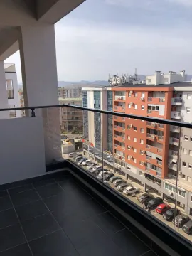 View from the balcony overlooking neighboring buildings and a parking lot. - image 31